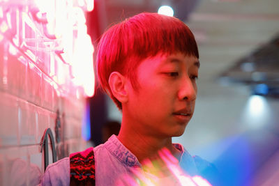 Close-up of man in sunglasses by illuminated store 