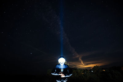 Low angle view of illuminated lighting equipment against sky at night