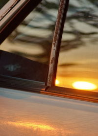 Close-up of glass window against orange sky