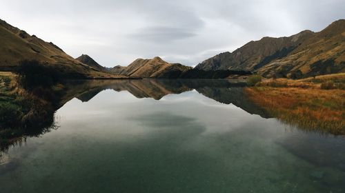 Scenic view of lake and mountains against sky