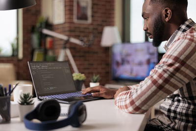 Midsection of man using digital tablet in office