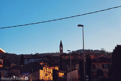 Buildings in city against clear blue sky