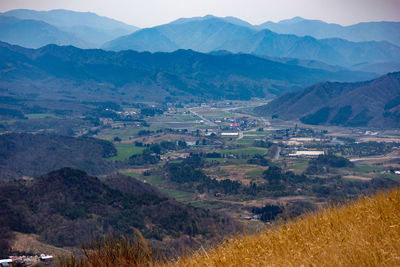 Scenic view of agricultural field and mountains against sky