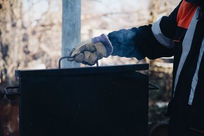 Midsection of man holding tool box outdoors