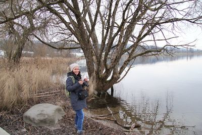 Portrait of woman standing at lakeshore