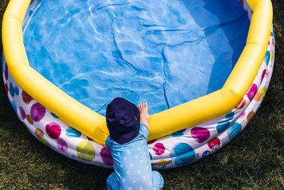 High angle view of baby boy by wading pool