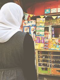 Rear view of woman standing against multi colored wall