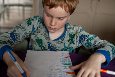 Girl drawing on book at home