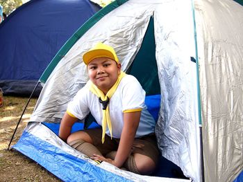 Portrait of boy sitting in tent