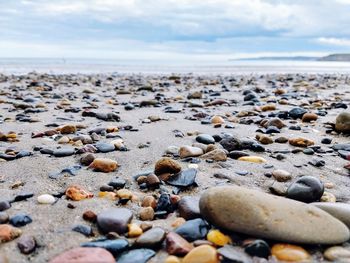 Stones on beach against sky