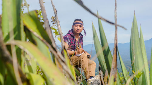 Low angle view of woman standing by plants against sky