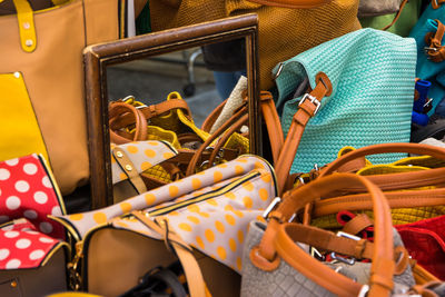 High angle view of handbags by mirror for sale at market stall