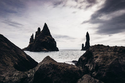 Rocks on beach against sky