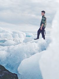 Full length of man standing on snow against sky