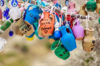 Close-up of multi colored jugs hanging on stick