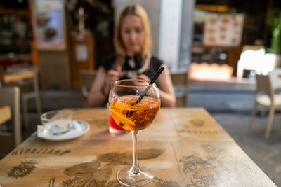 Woman with drink on table in restaurant