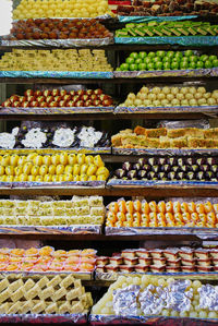 Various traditional, colorful indian sweets displayed at a tiny shop, india