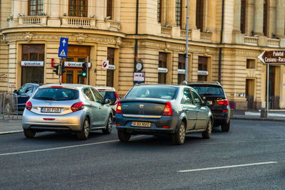 Cars on road by buildings in city