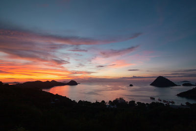 Scenic view of sea against dramatic sky during sunset