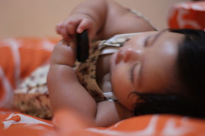 Close-up of baby lying on bed