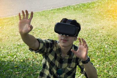 High angle view of man wearing virtual reality while standing on field