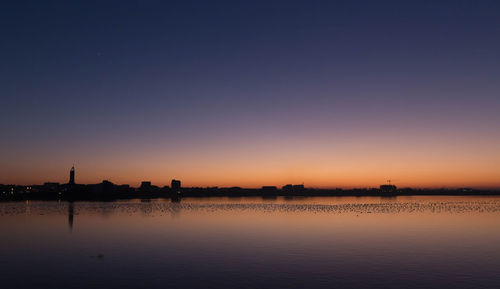 Scenic view of silhouette trees against clear sky during sunset