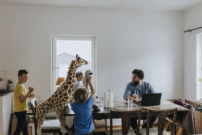 Man working from home and taking care of children