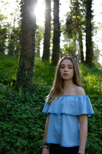 Portrait of teenage girl standing at forest