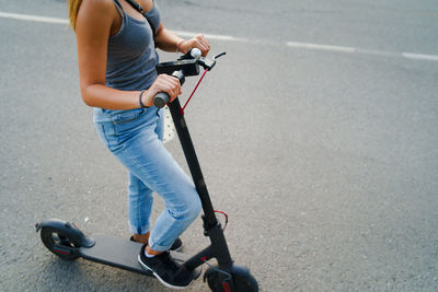 Low section of man riding bicycle on road