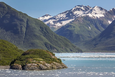 Scenic view of sea by mountains during winter