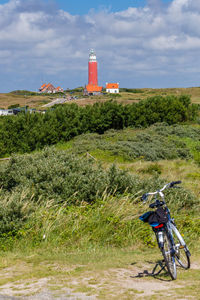 Bicycle riding motorcycle on road against cloudy sky