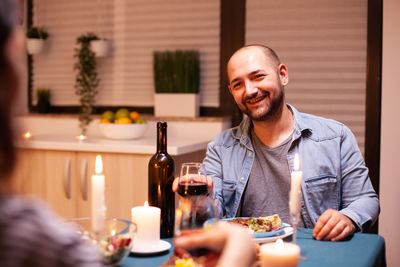 Young man using mobile phone while sitting on table