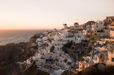 Aerial view of townscape by sea against sky