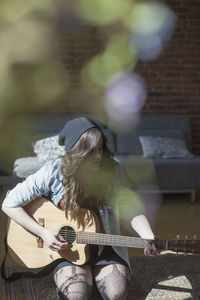 Young woman playing an acoustic guitar