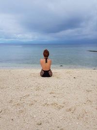 Rear view of man sitting on beach