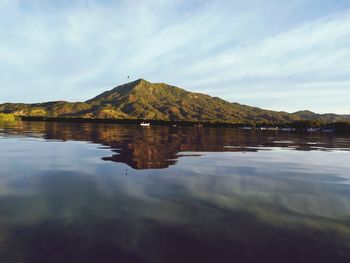 Scenic view of lake by mountain against sky