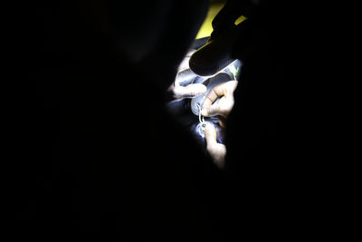 Close-up of hands against black background