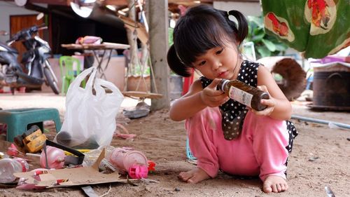 Full length of cute girl playing with toys while sitting outdoors