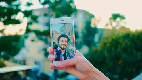 Midsection of woman using mobile phone outdoors