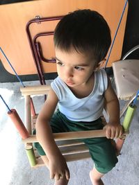 High angle view of cute boy sitting in kitchen