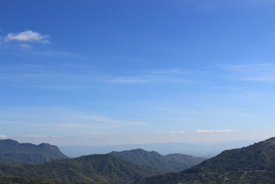 Scenic view of mountains against blue sky