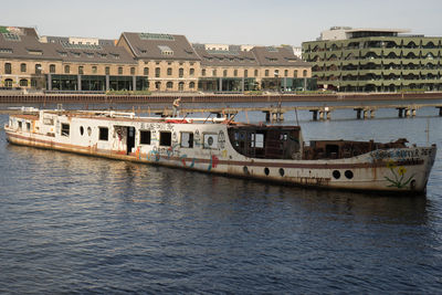 Boats in river with city in background