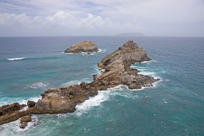 Scenic view of rock formation in sea against sky