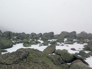 Rocks on landscape against clear sky