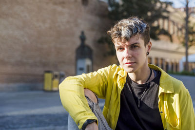 Portrait of a non binary person looking at camera while posing outdoors. person