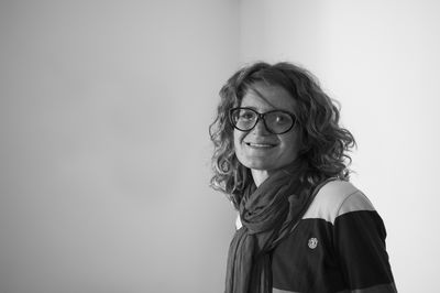 Portrait of young woman standing against wall