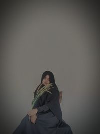 Portrait of woman standing against wall