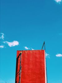 Low angle view of red crane against blue sky
