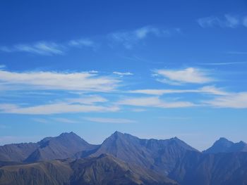 Scenic view of mountains against blue sky