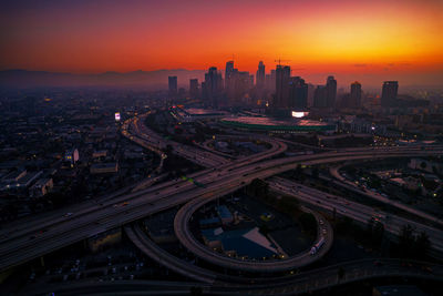 High angle view of illuminated cityscape at sunset